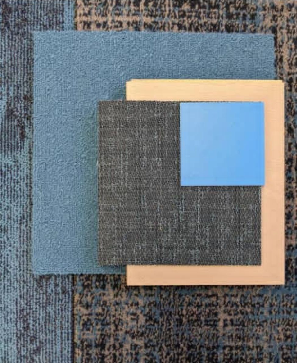 Carpet tile samples in blues and greys laid over a patterned floor