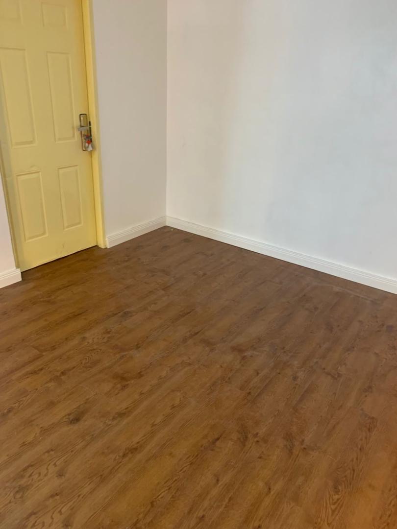 Warm wood-effect flooring laid through a bright room
