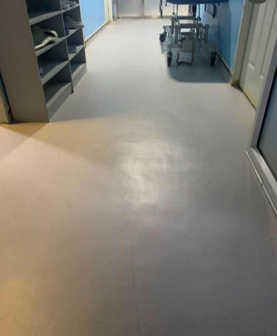Pale grey sheet vinyl running down a clinical corridor