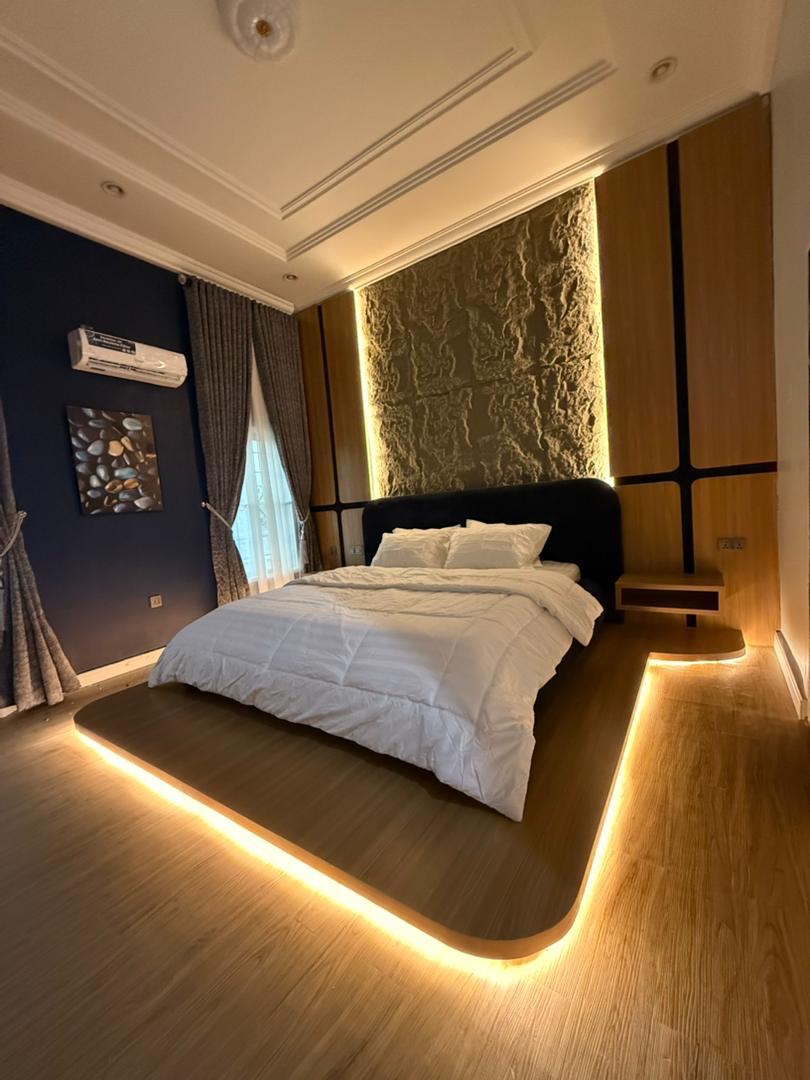 Bedroom with a lit platform bed over wood flooring